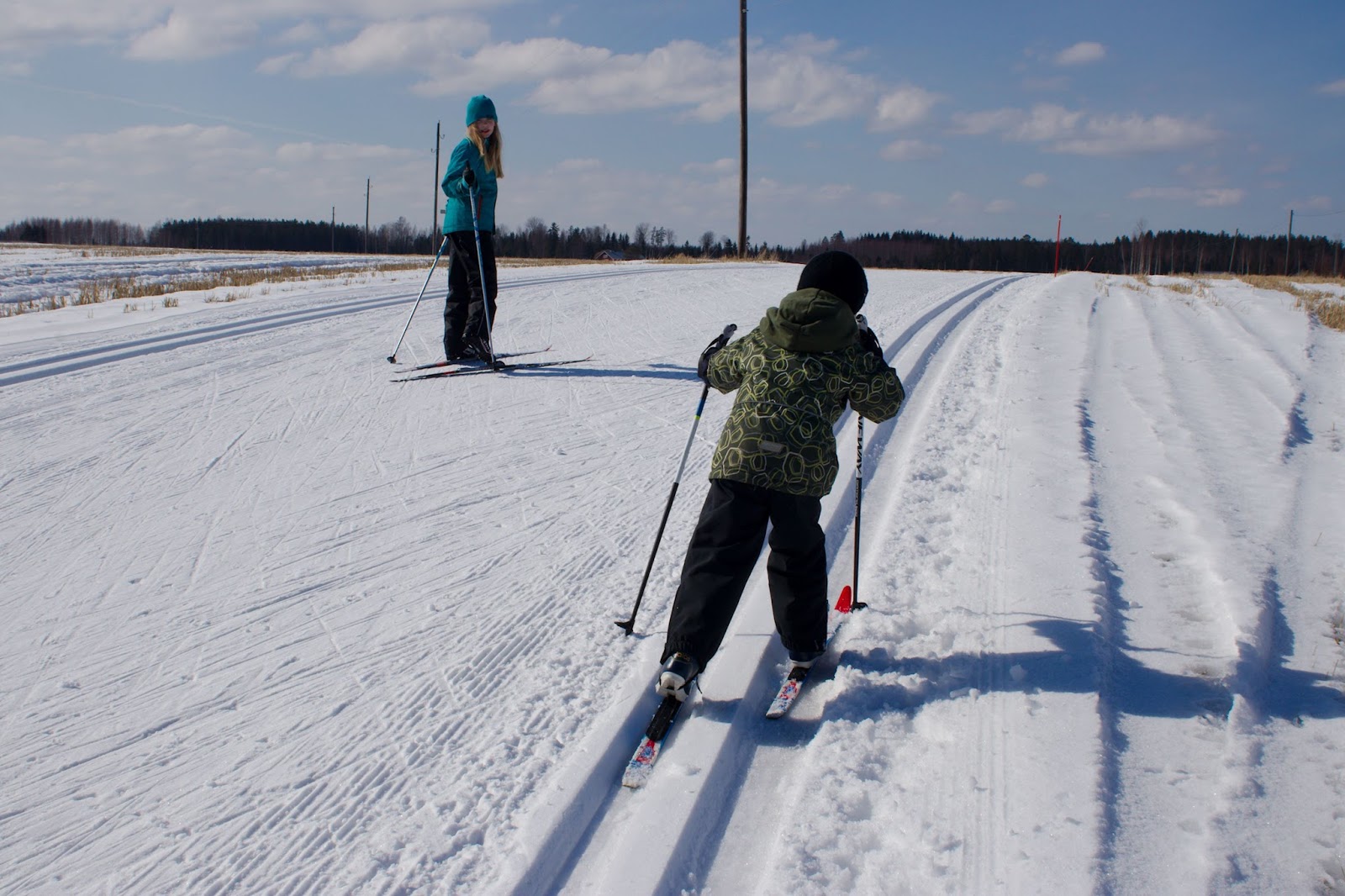 Lapset hiihtämässä latumajalta lähtevää latua