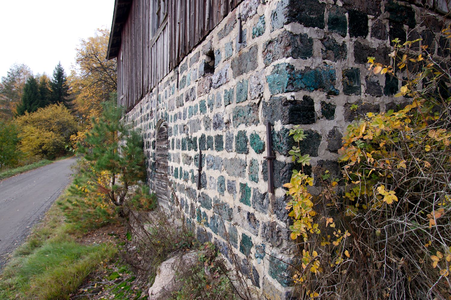 Vanhan talon kivijalka, jonka kivet hohtavat vihreinä